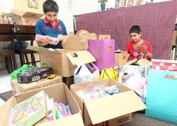 Brothers, P. Sacheen, 10 (left) and P. Rovan, eight, (right) sorting out books, stationaries and toys collected to be given to other children at their house at Bandar Putra, Kulai on Thursday (June 4).