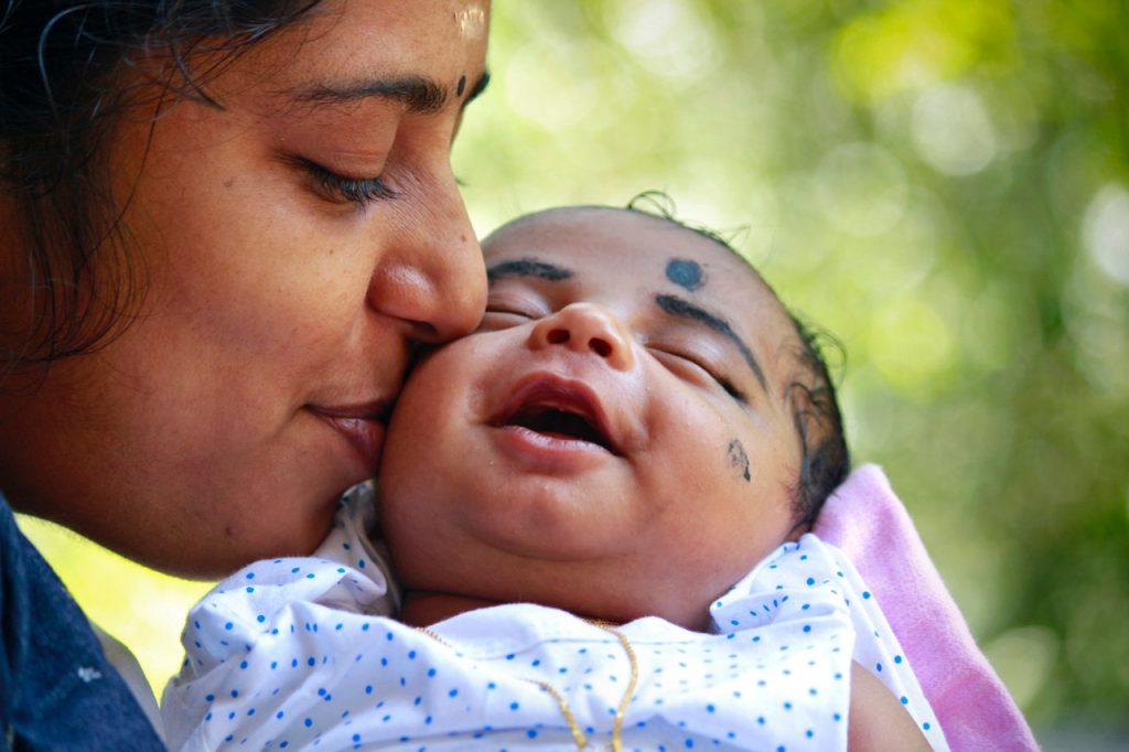 mother kissing child on cheek 1586257