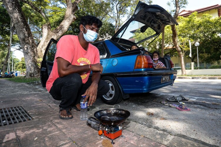 PENANG 24/12/2020: S. Ganesh (middle), 33 pictured with his family as they spent their days living in their car after their house caught on fire here at Padang Polo on December 24th. PICTURE BY SAYUTI ZAINUDIN